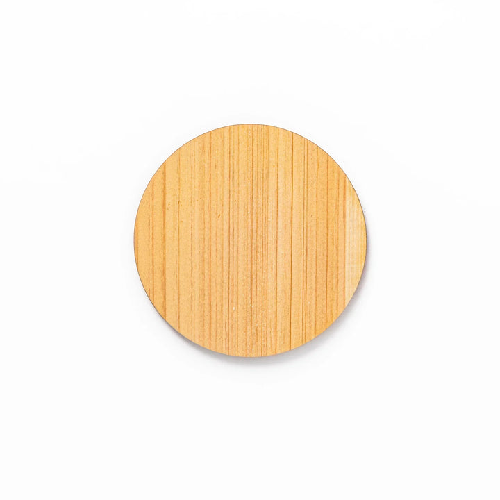 Round hinoki wood coaster with engraved sesame lattice pattern, featuring warm natural grain and a finely detailed geometric design.