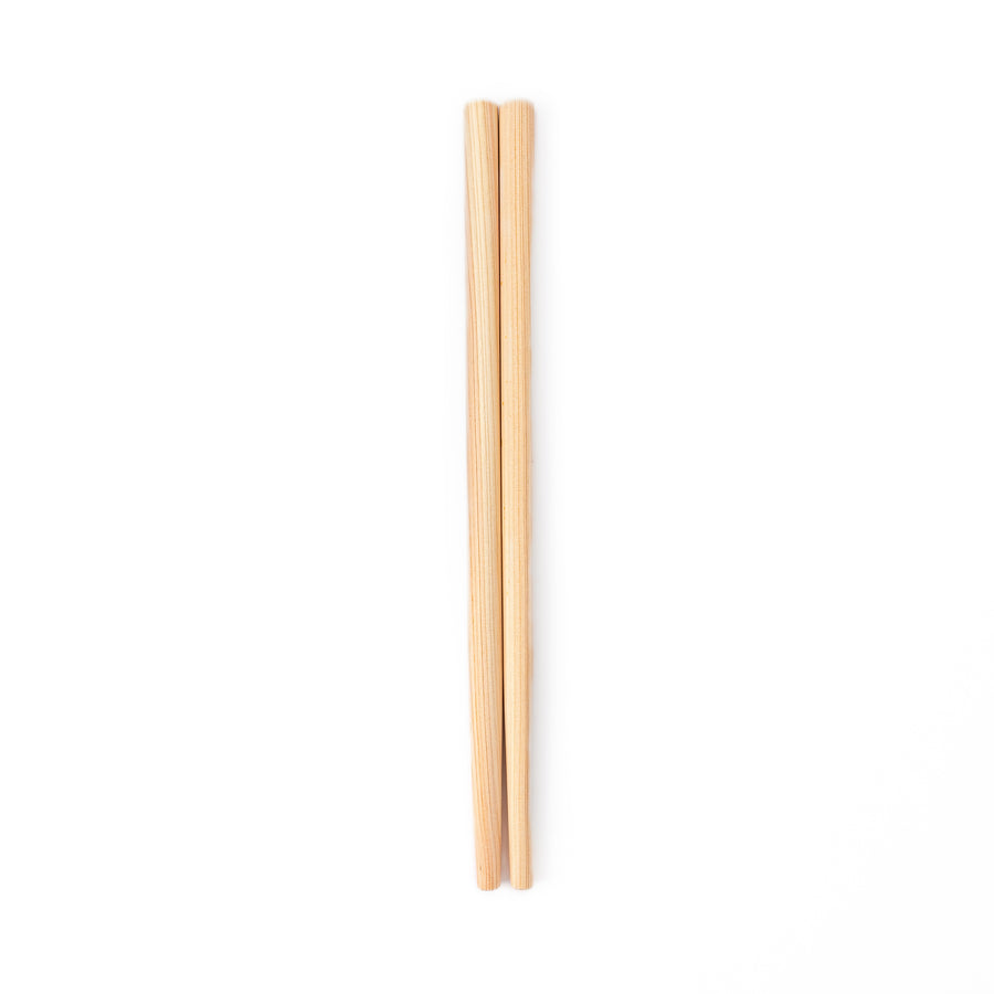 A pair of thick Japanese tempura cooking chopsticks made from light natural wood showcasing a minimalist and sturdy design