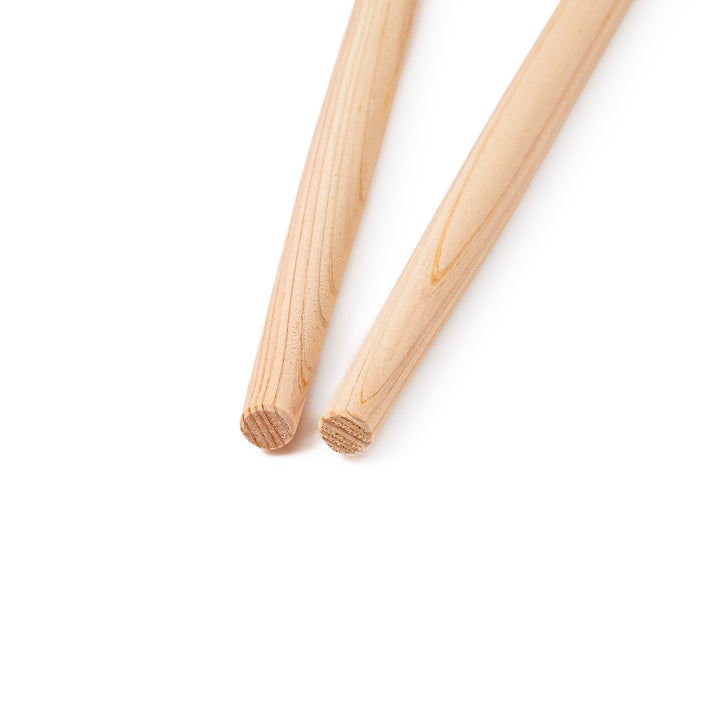 A pair of thick Japanese tempura cooking chopsticks made from light natural wood showcasing a minimalist and sturdy design