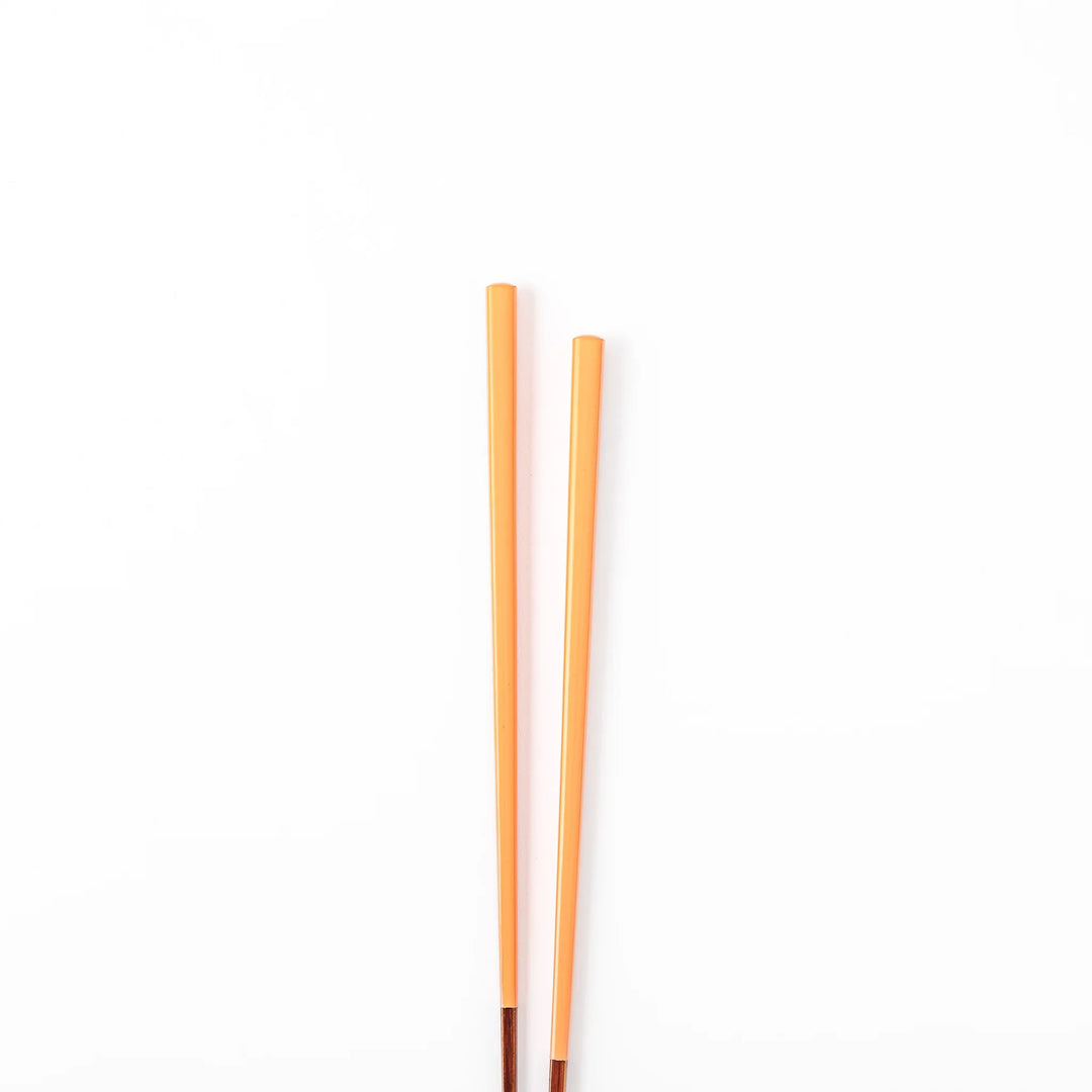 Pair of persimmon orange Japanese traditional color bamboo chopsticks with fine tips for precise and elegant dining