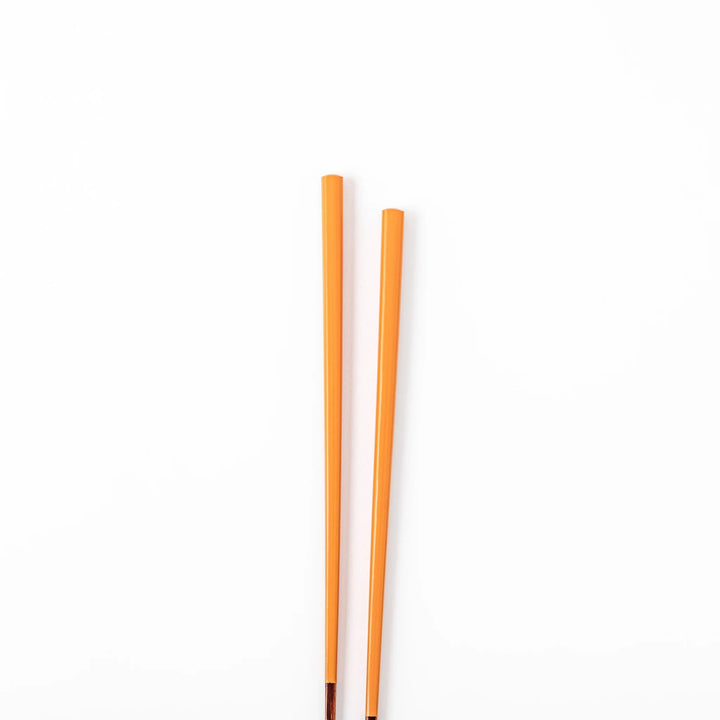 Pair of tangerine orange Japanese traditional color bamboo chopsticks with fine tips for a precise and elegant dining experience
