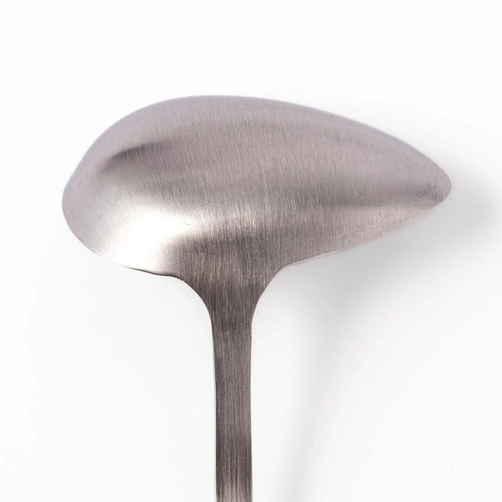 Japanese stainless steel soup ladle with long handle and deep curved bowl for serving soups and stews.