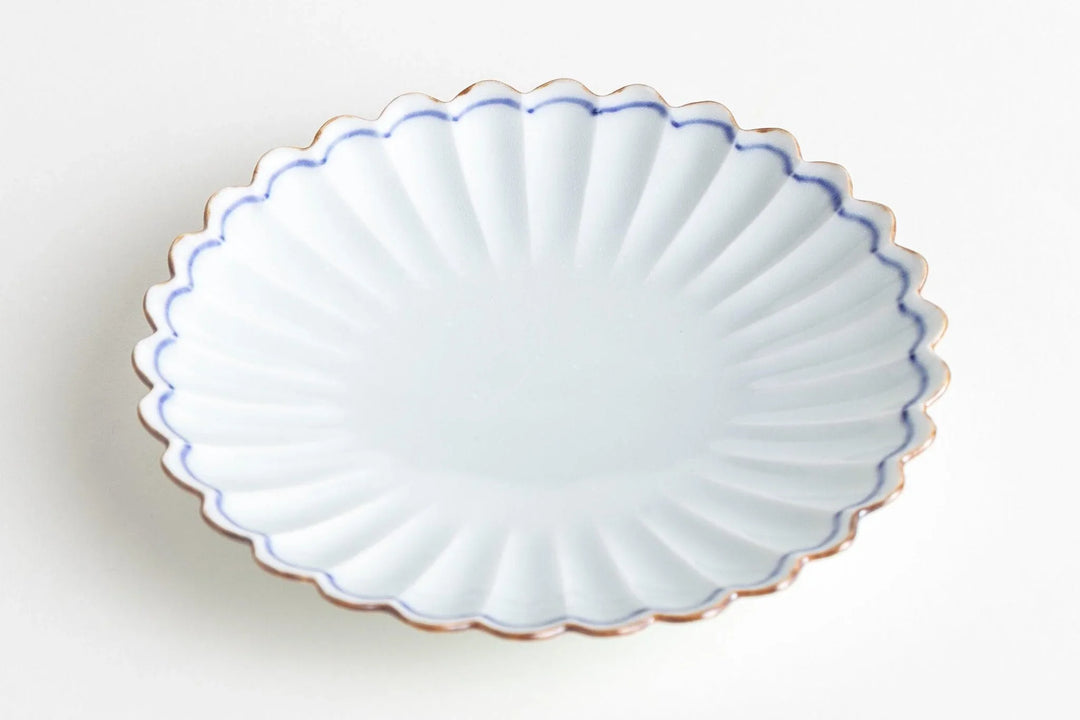 White chrysanthemum-shaped porcelain plate with scalloped rim and soft blue edge, ideal for serving small dishes.