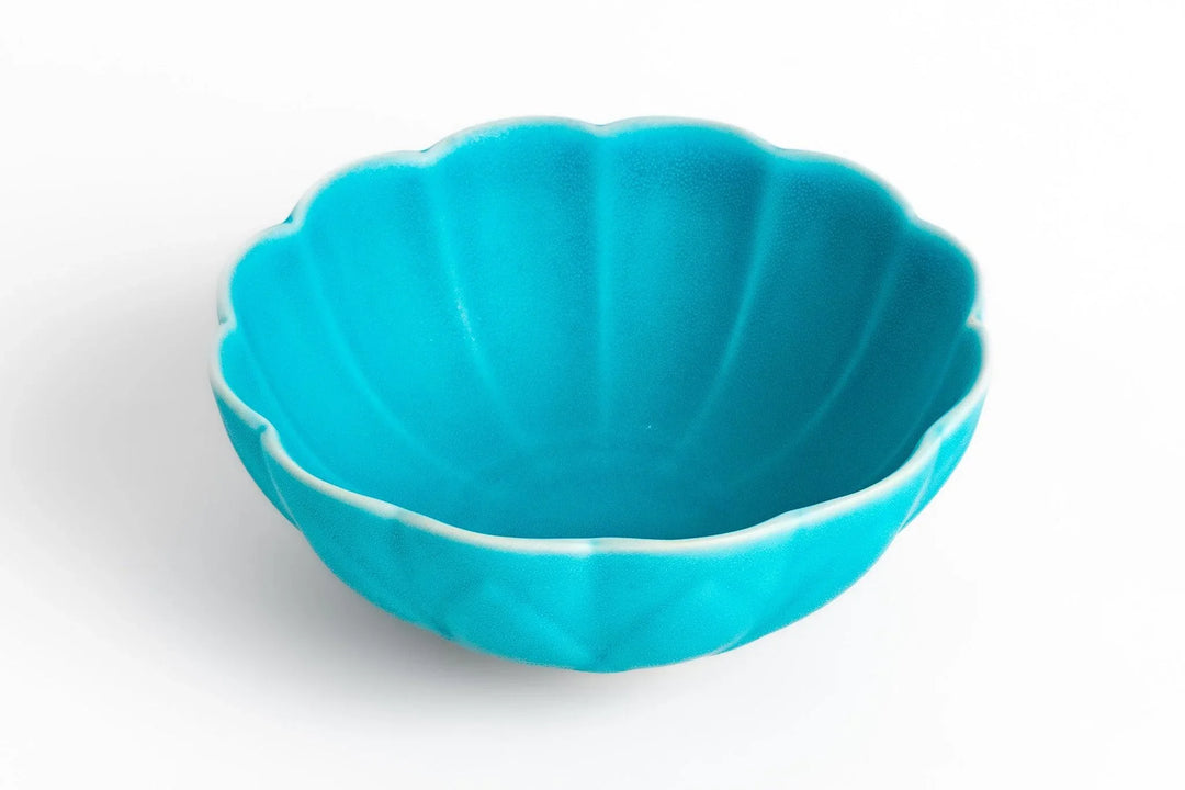 Turquoise scalloped ceramic bowl with a smooth glazed finish displayed on a clean white background