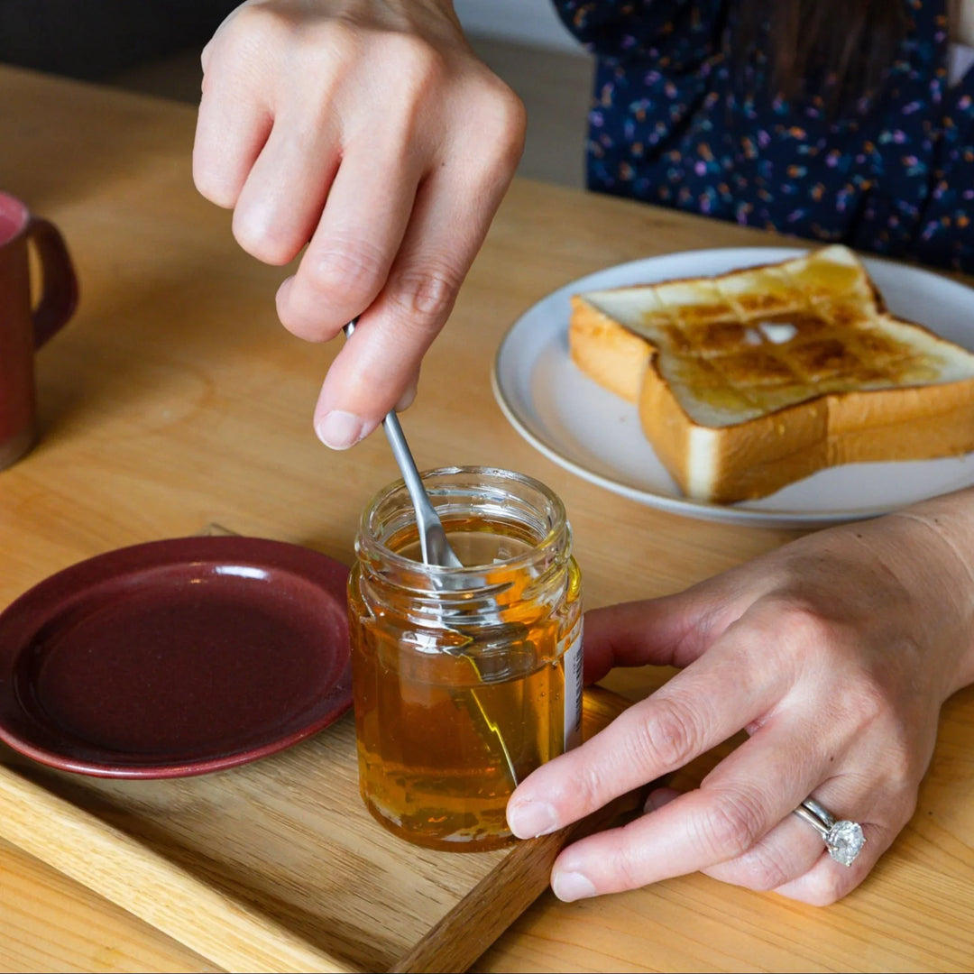 Nami dipping aux japanese honey spoon into jar sweet syrup breakfast table setting buttered toast cup