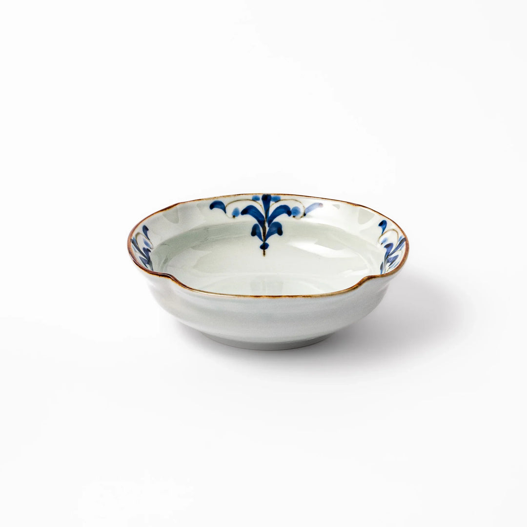 White ceramic cereal bowl with a scalloped rim, decorated inside with blue leaf motifs and a brown-accented edge.