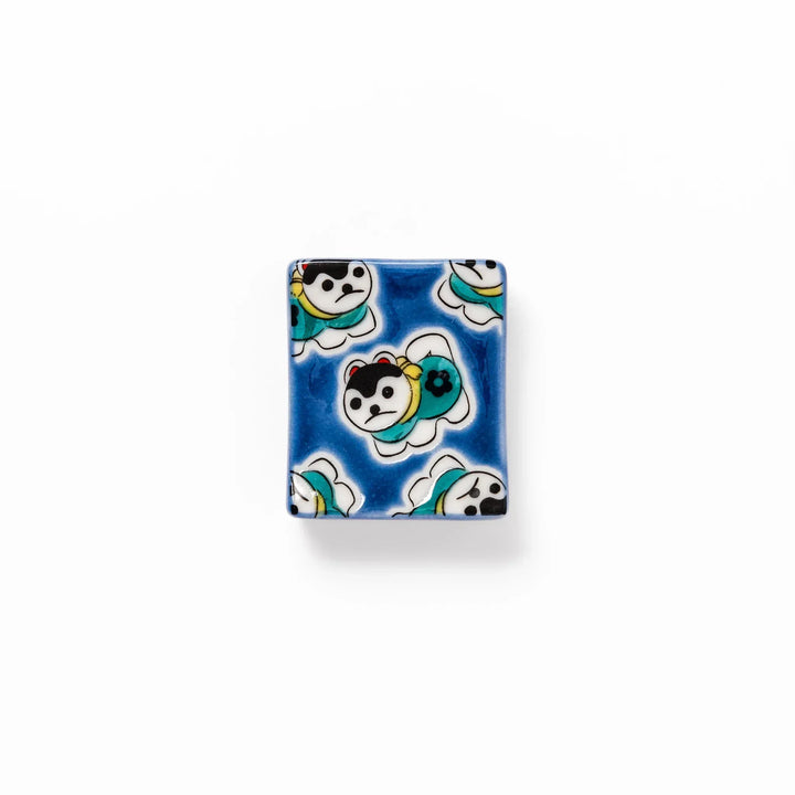 Rectangular Japanese ceramic chopstick rest with deep blue background and playful lucky dog motifs.