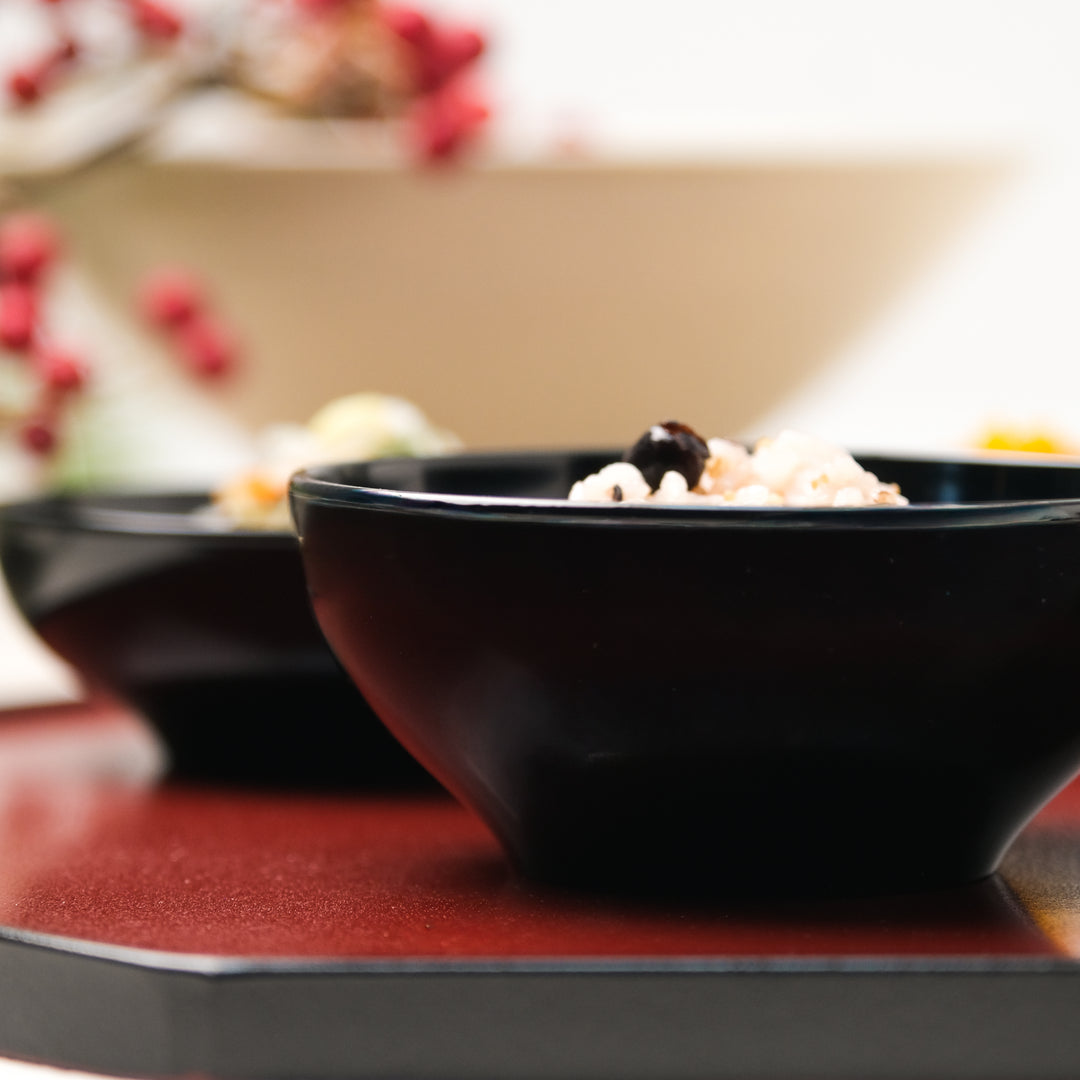 Close-up of a black lacquer rice bowl on a red Japanese lacquer tray
