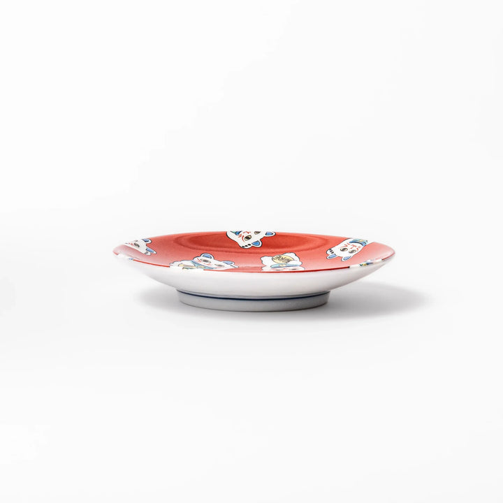 Round Japanese ceramic sauce dish with red background and maneki neko cat design for soy sauce or condiments.