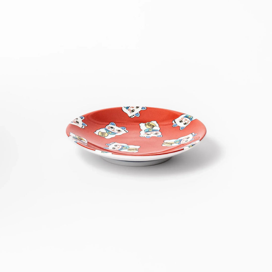 Round Japanese ceramic sauce dish with red background and maneki neko cat design for soy sauce or condiments.