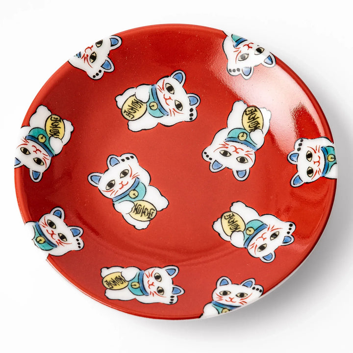 Round Japanese ceramic sauce dish with red background and maneki neko cat design for soy sauce or condiments.