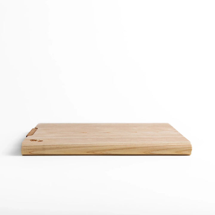 Medium Hinoki wood cutting board with natural grain, side handle, engraved motif, and smooth finish, crafted in Japan