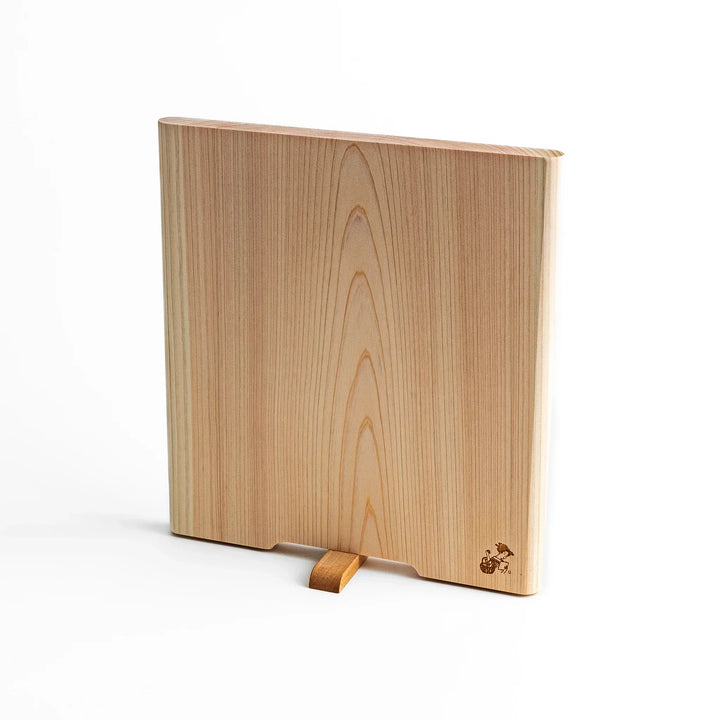 Medium Hinoki wood cutting board with natural grain, side handle, engraved motif, and smooth finish, crafted in Japan