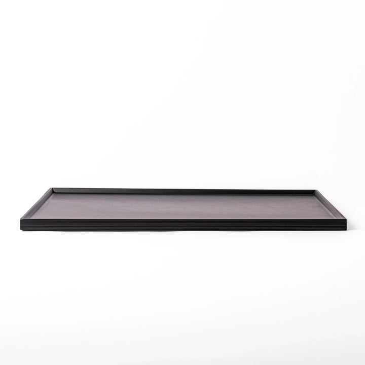 Modern Japanese black lacquer serving tray with horizontal grain texture and side grooves for easy use.