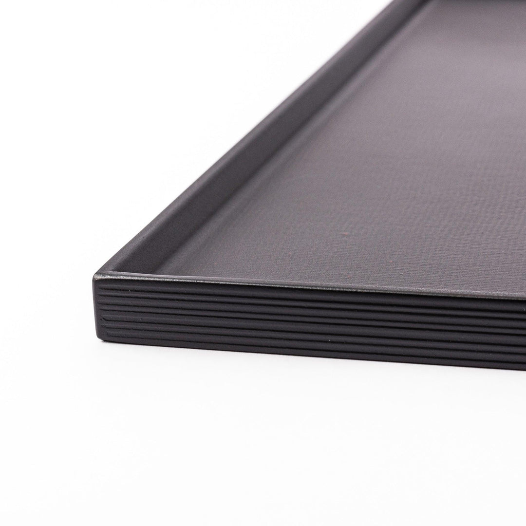 Modern Japanese black lacquer serving tray with horizontal grain texture and side grooves for easy use.