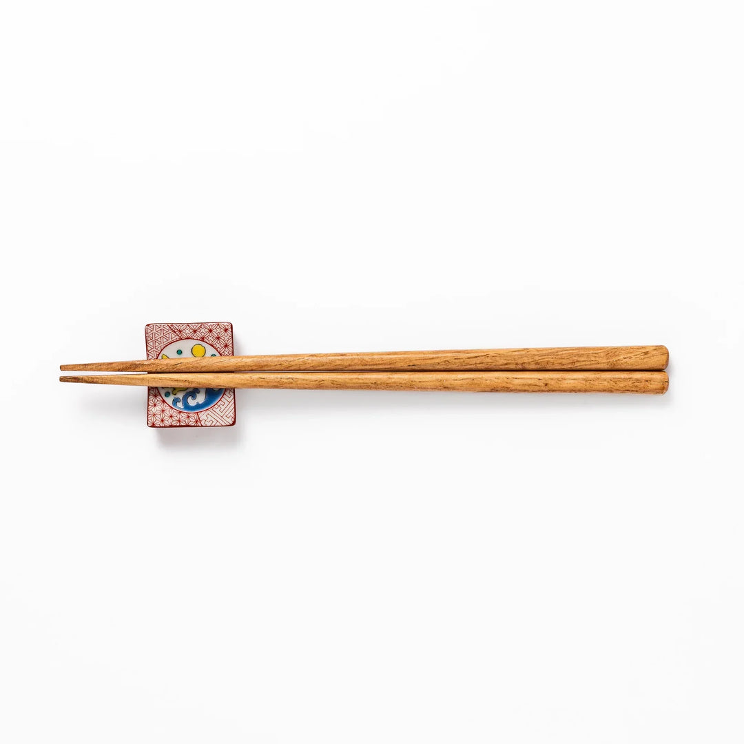 Rectangular Japanese ceramic chopstick rest with red geometric pattern and moon rabbit motif for charm.