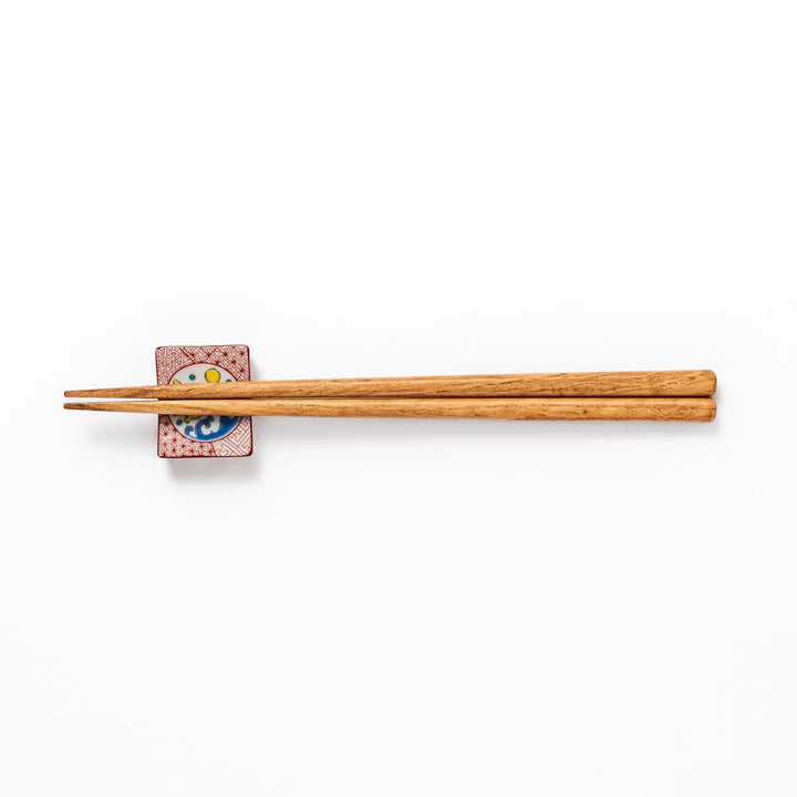 Rectangular Japanese ceramic chopstick rest with red geometric pattern and moon rabbit motif for charm.