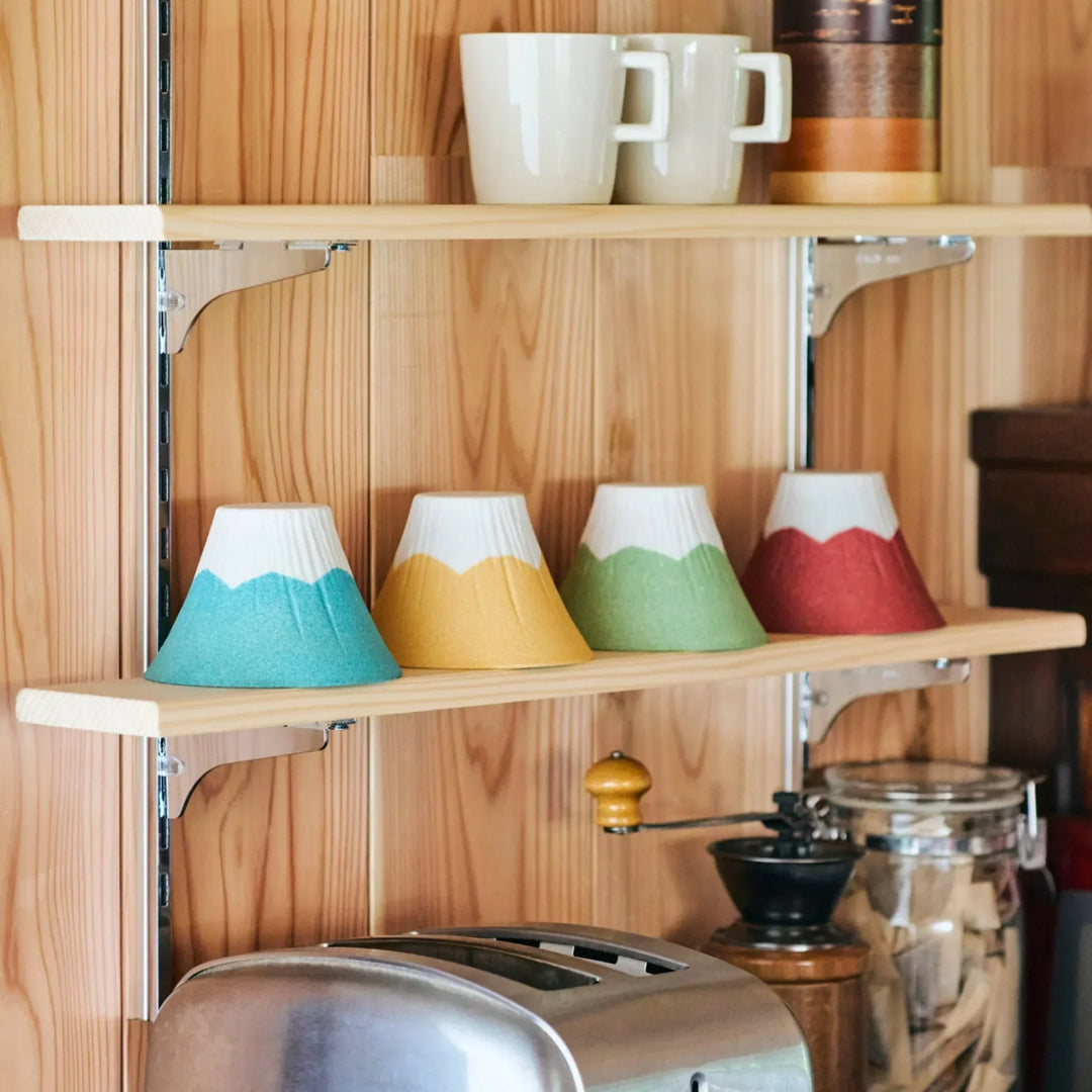 Colorful Mount Fuji shaped ceramic coffee filters handcrafted in Japan, beautifully displayed on wooden kitchen shelves.