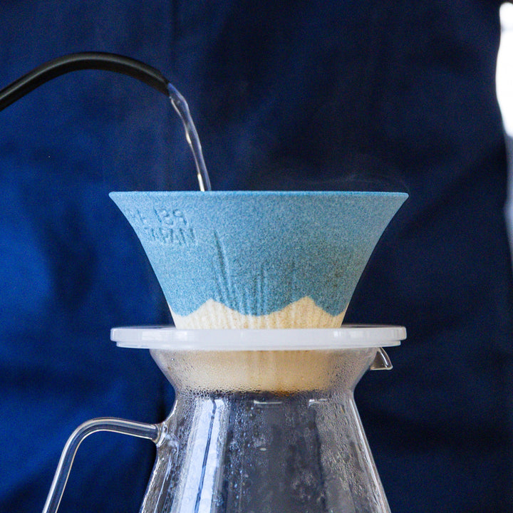 Hot water pouring through Mount Fuji ceramic coffee filter during pour over brewing