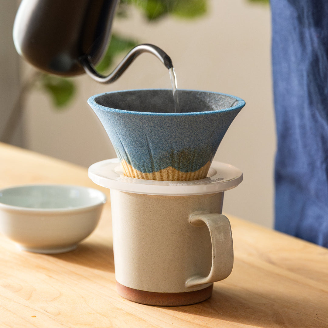 Close up of Mount Fuji ceramic coffee filter brewing fresh pour over coffee into mug