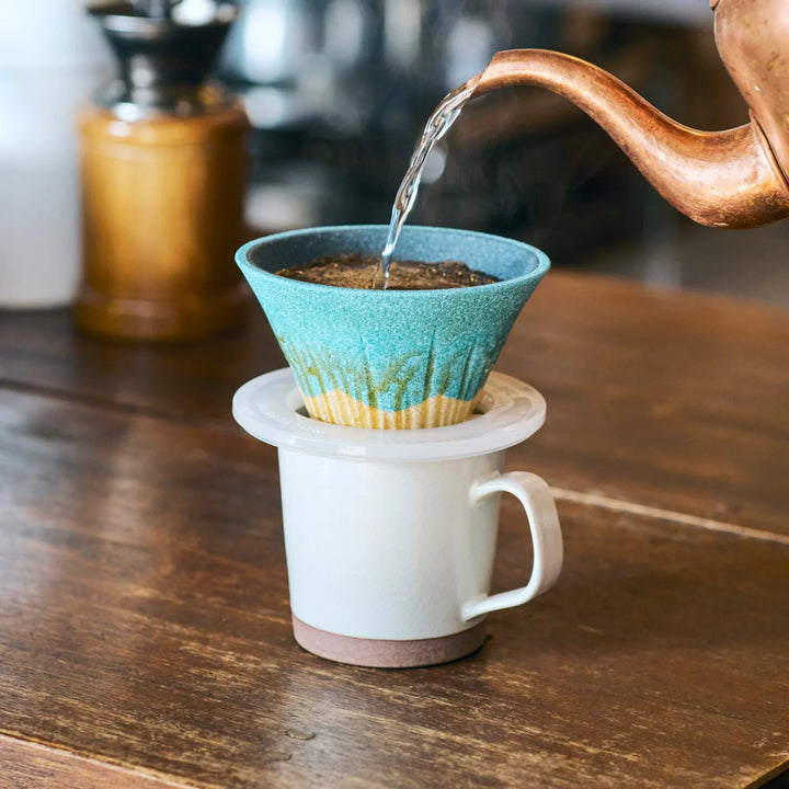 Turquoise Mount Fuji inspired ceramic coffee filter handcrafted in Japan, creating a soothing pour over moment with rising steam.