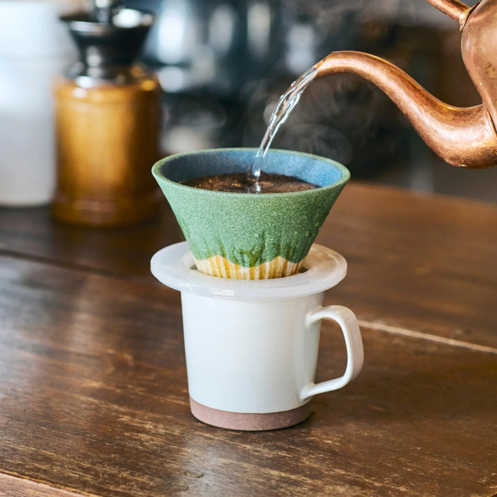 Handcrafted Japanese ceramic coffee filter shaped like Mount Fuji in matcha green, creating a calm and aromatic pour over brew.