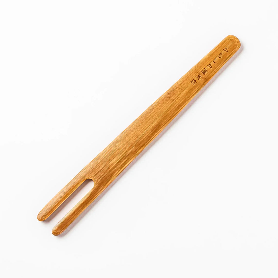 Bamboo natto stirring stick with a split-tip design and engraved Japanese text, ideal for mixing natto evenly and gently.