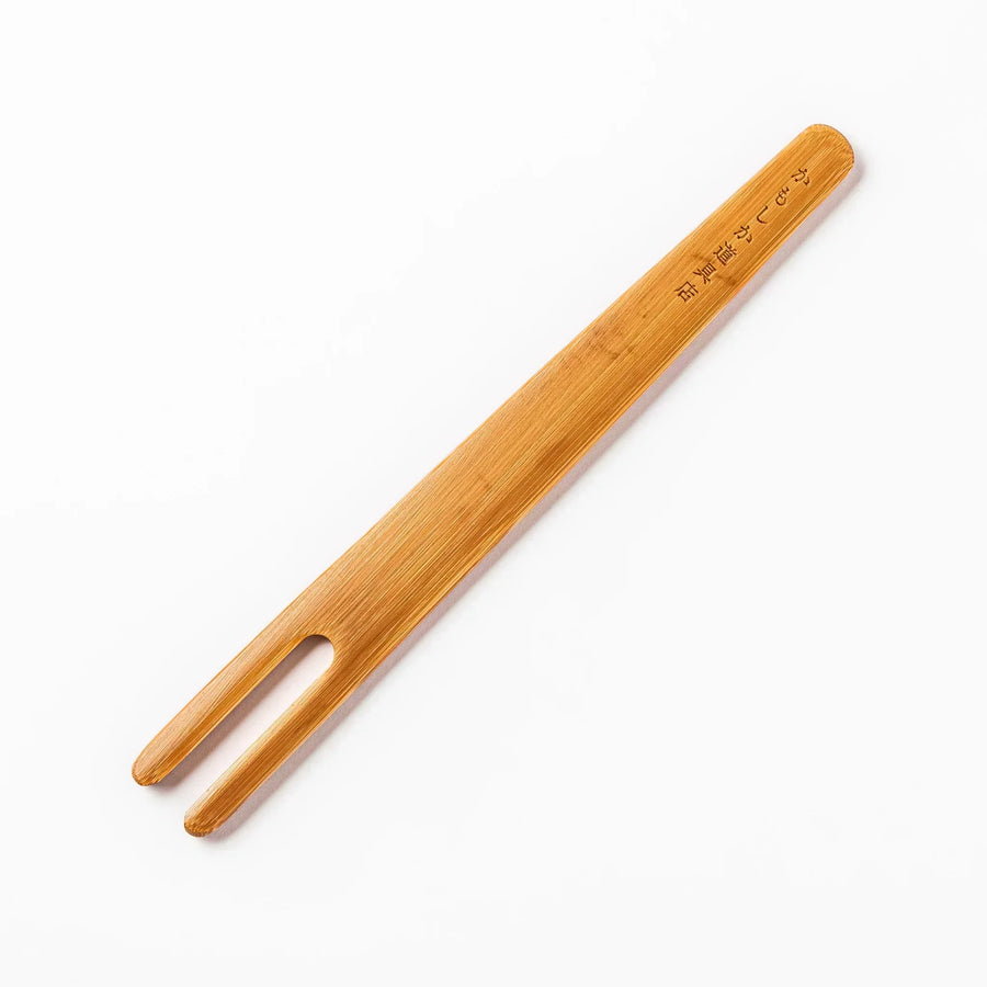 Bamboo natto stirring stick with a split-tip design and engraved Japanese text, ideal for mixing natto evenly and gently.