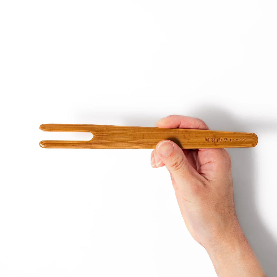 Bamboo natto stirring stick with a split-tip design and engraved Japanese text, ideal for mixing natto evenly and gently.
