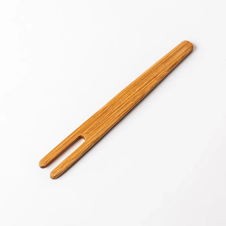 Bamboo natto stirring stick with a split-tip design and engraved Japanese text, ideal for mixing natto evenly and gently.