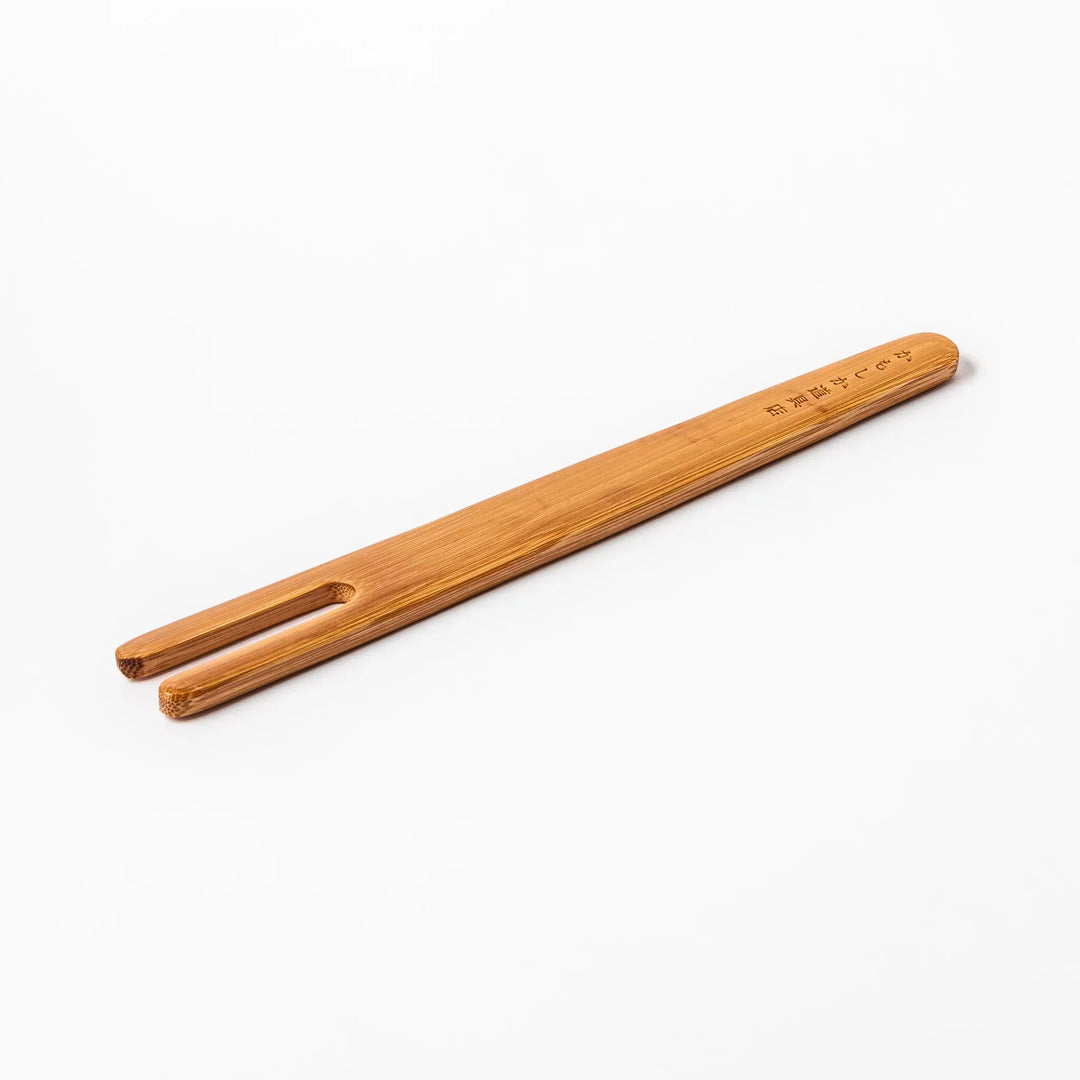 Bamboo natto stirring stick with a split-tip design and engraved Japanese text, ideal for mixing natto evenly and gently.