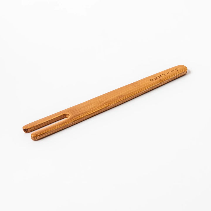 Bamboo natto stirring stick with a split-tip design and engraved Japanese text, ideal for mixing natto evenly and gently.