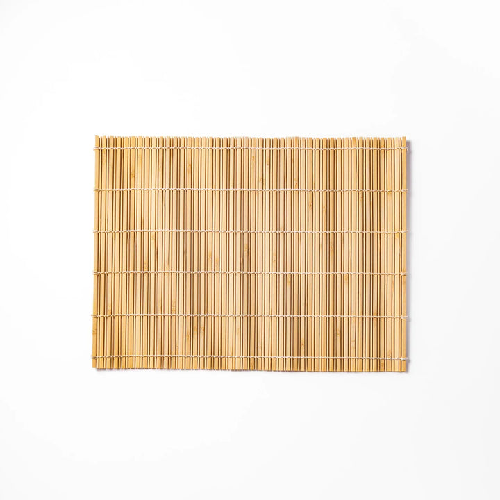 Natural bamboo table mat with vertical slats and white cord binding for earthy Japanese table settings.