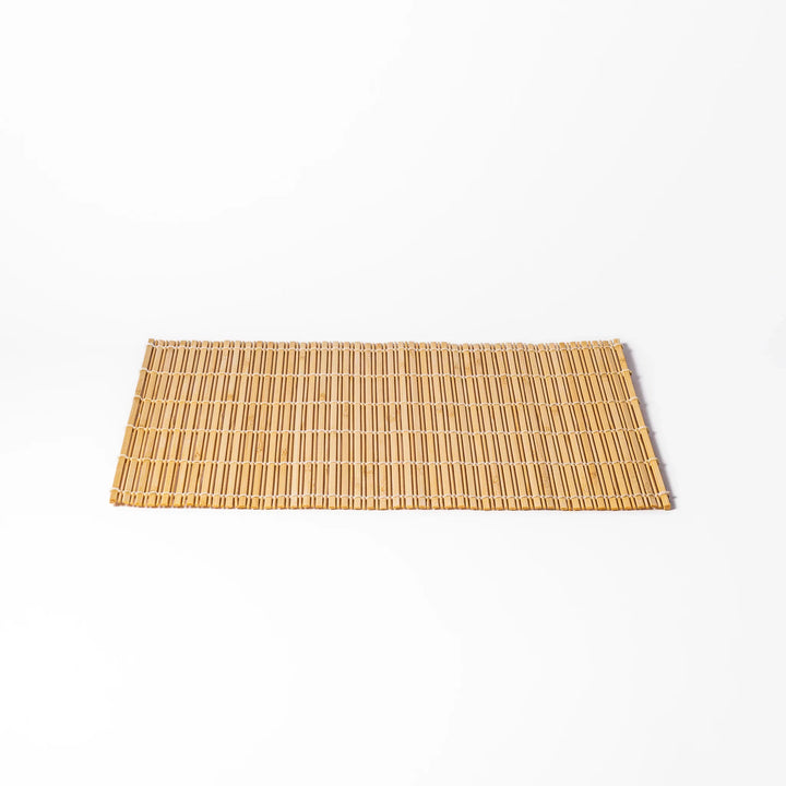 Natural bamboo table mat with vertical slats and white cord binding for earthy Japanese table settings.