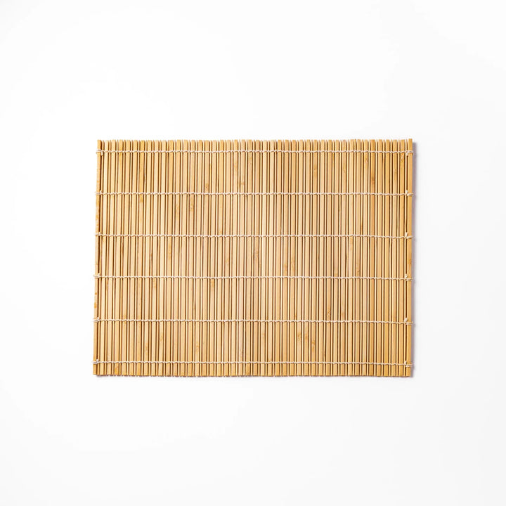 Natural bamboo table mat with vertical slats and white cord binding for earthy Japanese table settings.