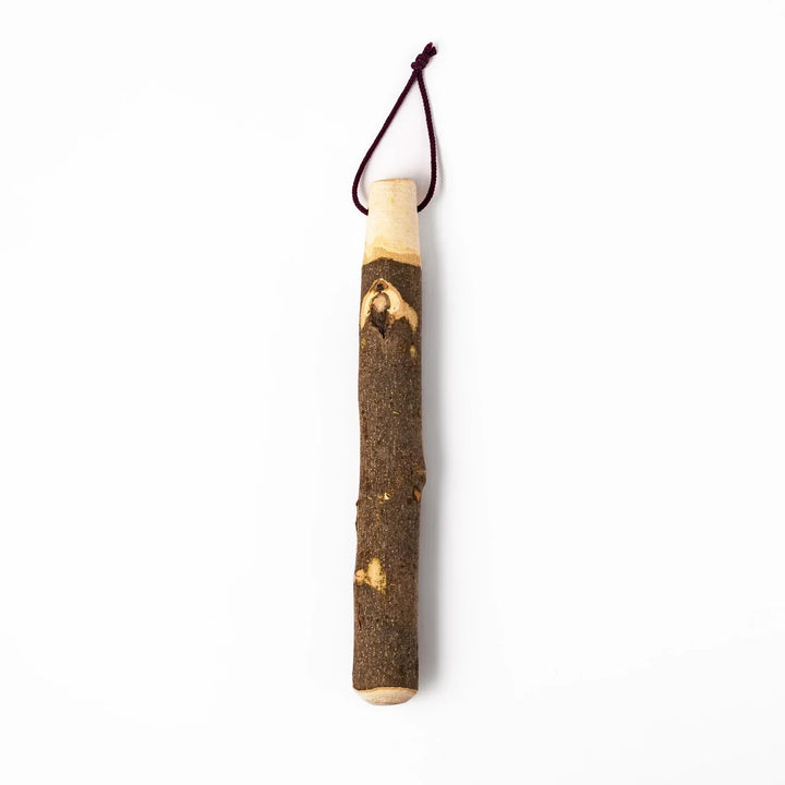 Natural sansho wood pestle featuring bark textures and a burgundy hanging cord, ideal for traditional Japanese grinding.