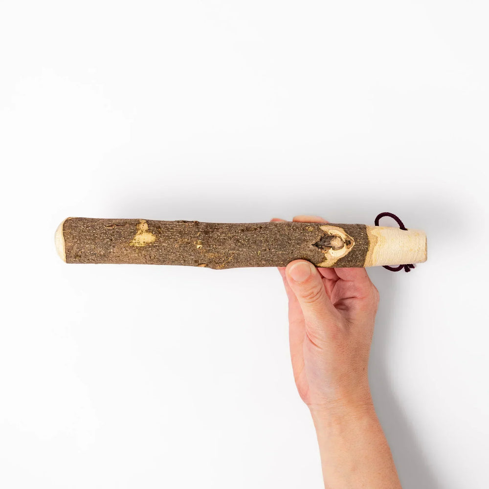 Natural sansho wood pestle featuring bark textures and a burgundy hanging cord, ideal for traditional Japanese grinding.