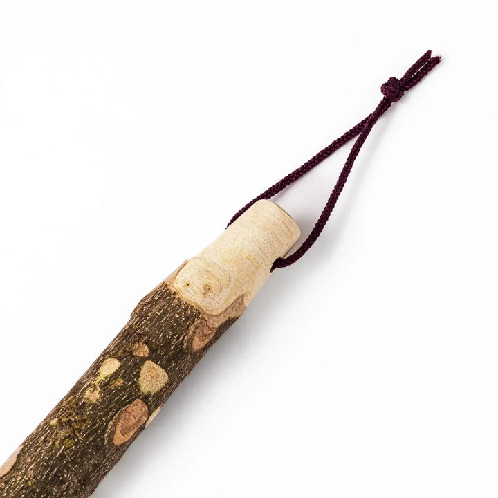 Natural sansho wood pestle featuring bark textures and a burgundy hanging cord, ideal for traditional Japanese grinding.