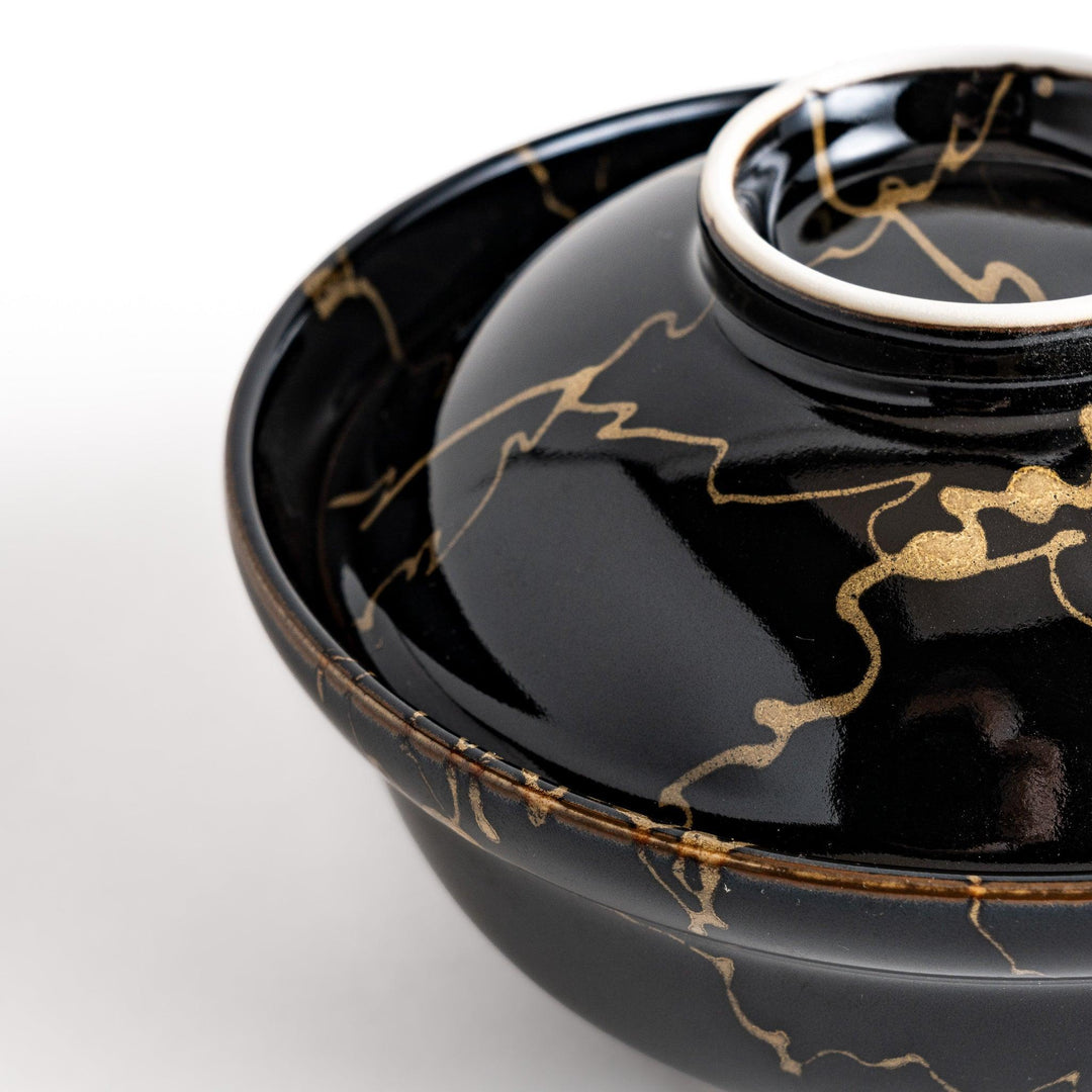 Black ceramic donburi bowl with gold marbled design and matching lid perfect for serving Japanese rice dishes.