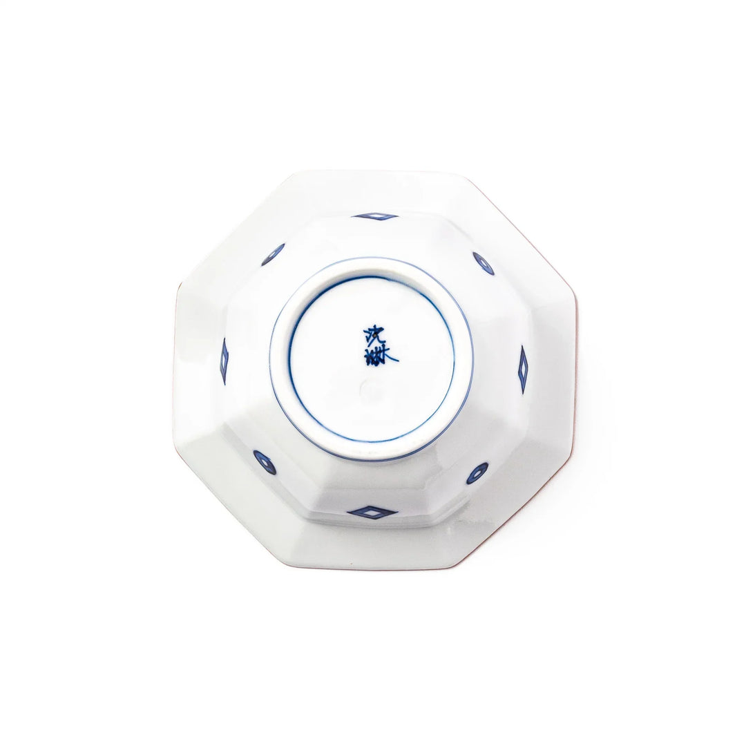 White octagonal dessert bowl with blue floral garland and red rim featuring fine geometric detailing.