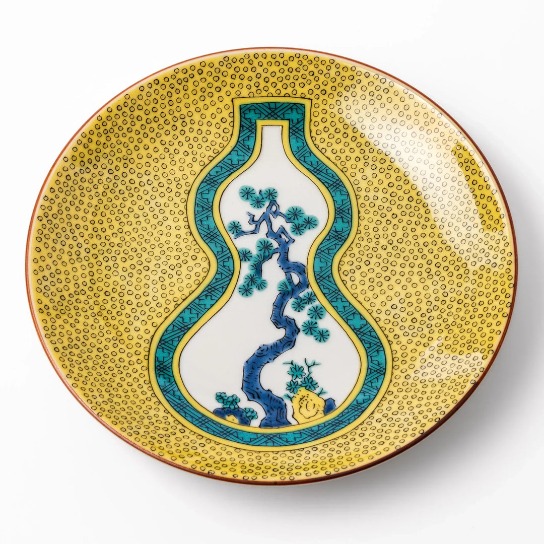 Japanese porcelain dessert plate with yellow patterned background gourd center blue pine and green leaves.
