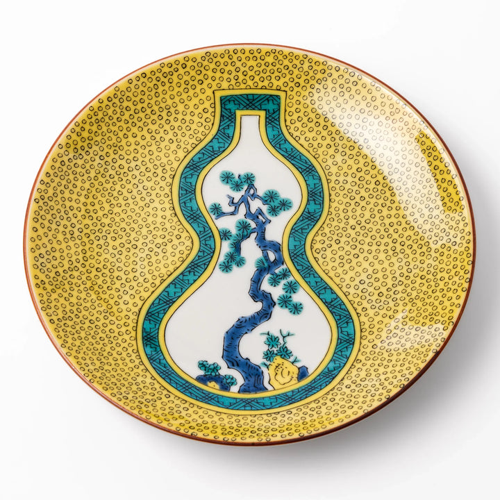 Japanese porcelain dessert plate with yellow patterned background gourd center blue pine and green leaves.