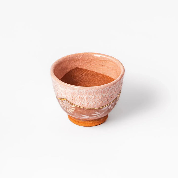 Pink crackle-glazed cup with gold accent and floral design, blending traditional charm and warmth.