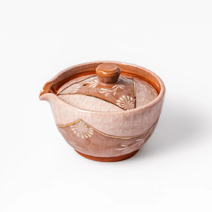 Turquoise crackle-glazed ceramic tea cup with floral patterns and earthy brown base, highlighting handcrafted beauty.