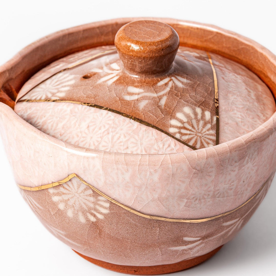 Turquoise crackle-glazed ceramic tea cup with floral patterns and earthy brown base, highlighting handcrafted beauty.