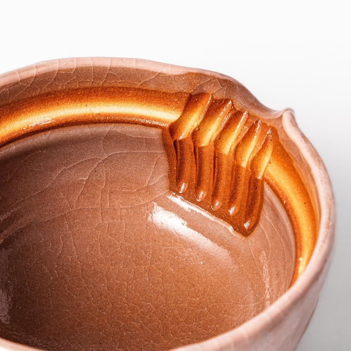 Turquoise crackle-glazed ceramic tea cup with floral patterns and earthy brown base, highlighting handcrafted beauty.