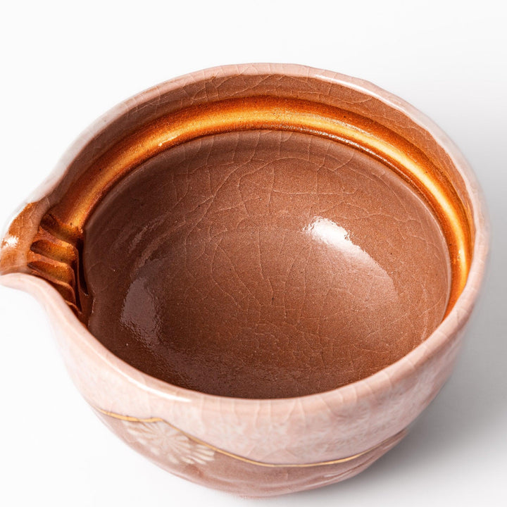 Turquoise crackle-glazed ceramic tea cup with floral patterns and earthy brown base, highlighting handcrafted beauty.