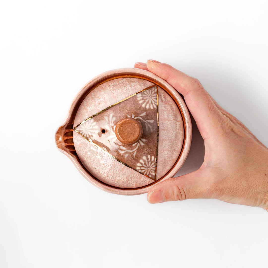 Turquoise crackle-glazed ceramic tea cup with floral patterns and earthy brown base, highlighting handcrafted beauty.