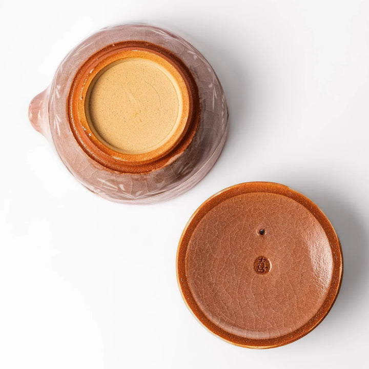 Turquoise crackle-glazed ceramic tea cup with floral patterns and earthy brown base, highlighting handcrafted beauty.