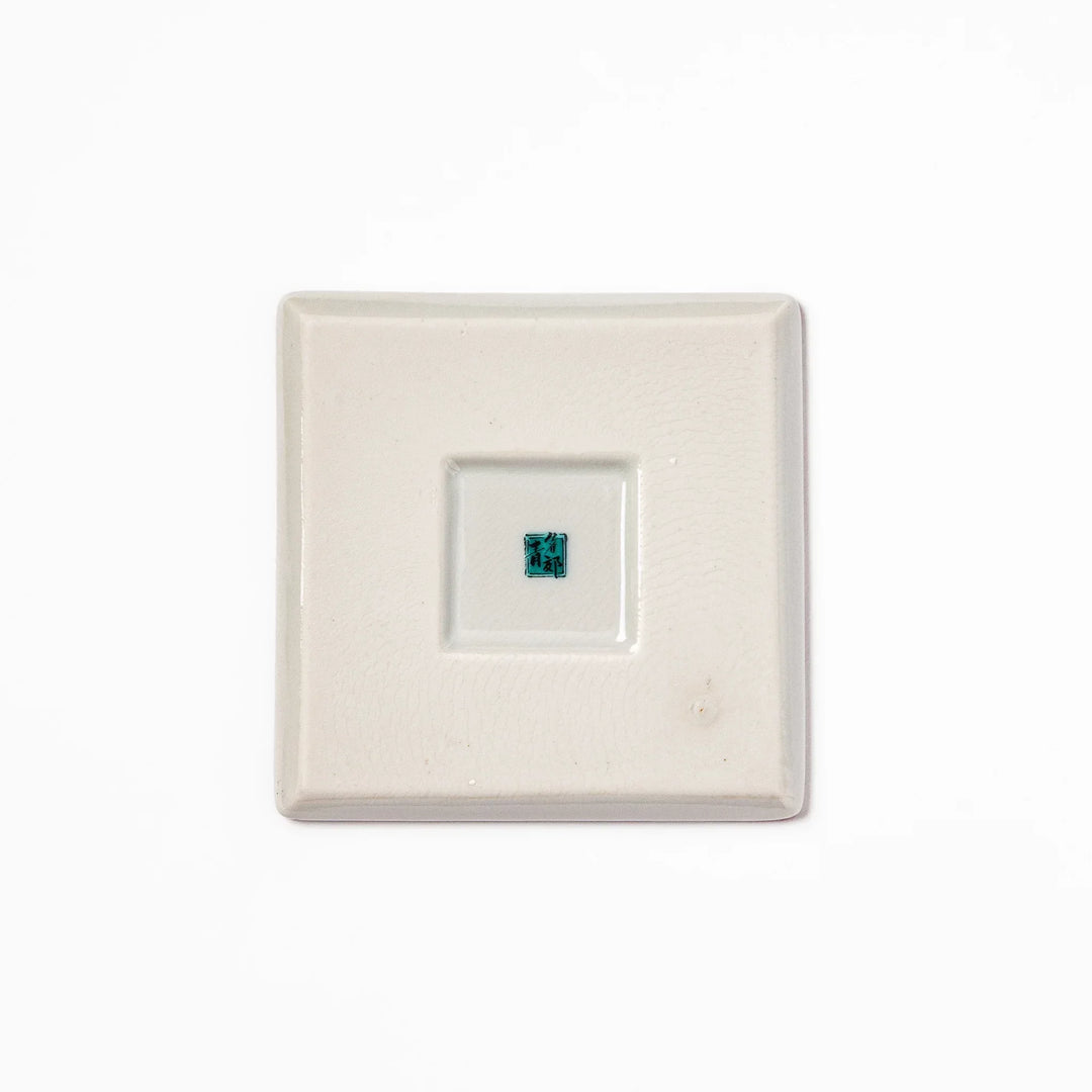 Square Japanese ceramic coaster with red and white checkered pattern and plum blossom motifs for dining.